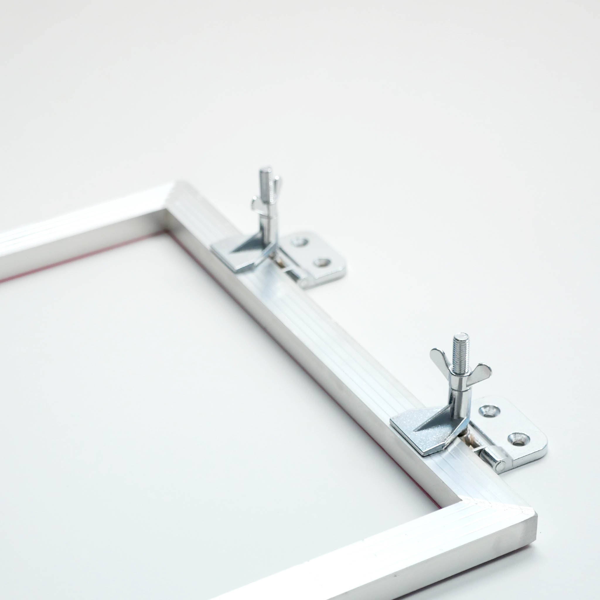 Siebzwingen montiert an einem Siebdruckrahmen.