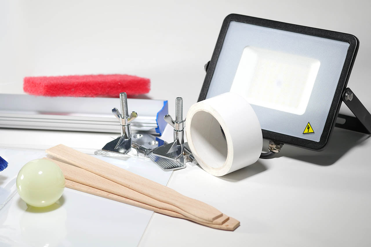 Eine Belichtungslampe, Siebzwingen, Gelblichtlampe, Folin, Siebklebeband und eine Beschichtungsrinne